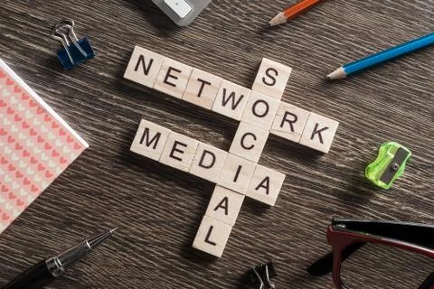 Conceptual media keywords on table with elements of game making crossword Foto stock