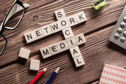 Conceptual media keywords on table with elements of game making crossword Foto stock