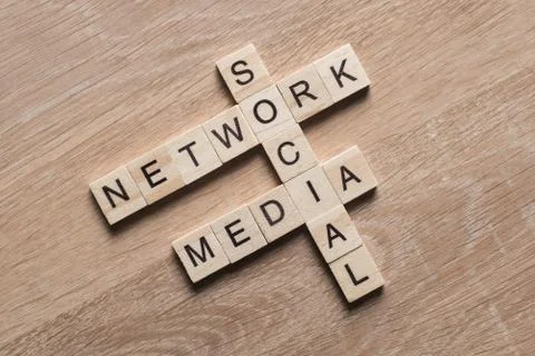 Conceptual media keywords on table with elements of game making crossword Foto stock