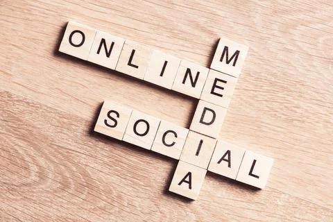 Conceptual media keywords on table with elements of game making crossword Foto stock