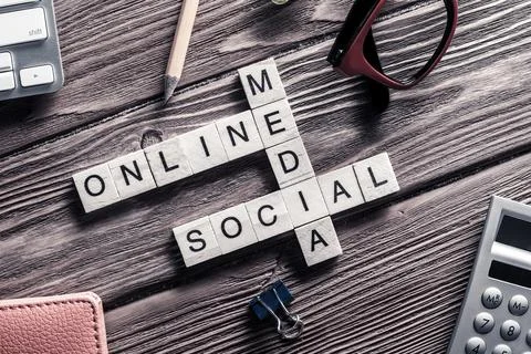 Conceptual media keywords on table with elements of game making crossword Foto stock