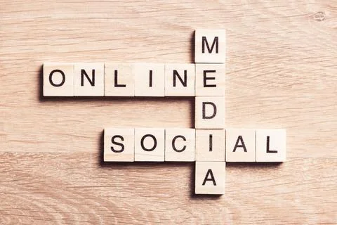 Conceptual media keywords on table with elements of game making crossword Foto stock