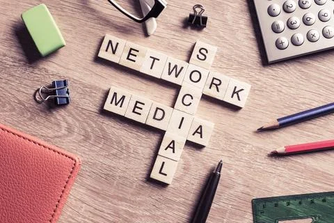 Conceptual media keywords on table with elements of game making crossword Stock Photos