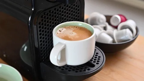 Conceptual modern coffee machine at home, on the table and a cup of fresh aromat Stockbeeldmateriaal 130044231