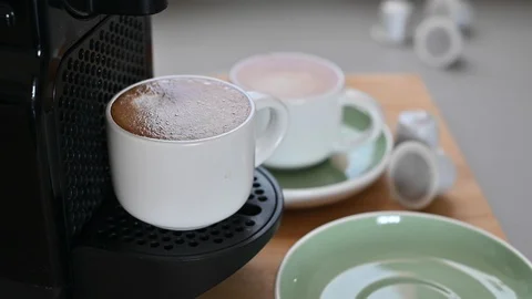 Conceptual modern coffee machine at home, on the table and a cup of fresh aromat Stockbeeldmateriaal 130044394
