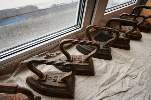 Conceptual photography - a set of antique cast iron irons on the surface of a Stock Photos