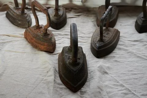 Conceptual photography - a set of antique cast iron irons on the surface of a Stock Photos