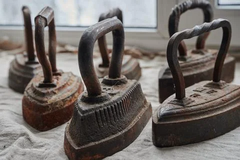 Conceptual photography - a set of antique cast iron irons on the surface of a Stock Photos