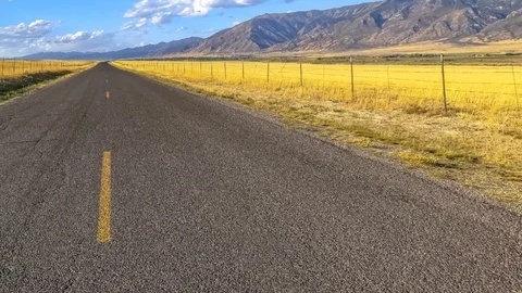 Conceptual remix of horizontal pan Highway along mountain under brilliant sky in Stock Footage 120612476