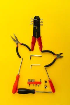 Conceptual set of tools on yellow background. It looks like guitar. Working h Stock Photos
