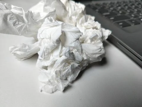 Conceptual shot of crumpled tissues next to a laptop keyboard Фото