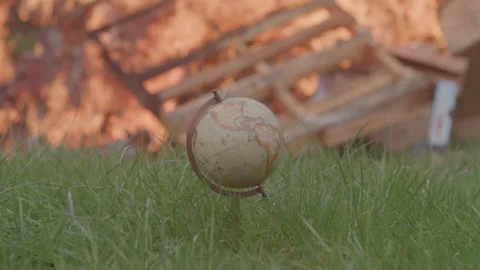 Conceptual Shot of a World Globe in Grass in Front of a Large Outdoor Fire 動画素材 208803402