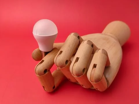 A conceptual studio shot featuring a small white USB LED light bulb being h.. Фото