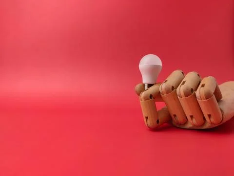 A conceptual studio shot featuring a small white USB LED light bulb being h.. Фото