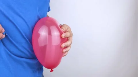 Conceptual video. The man holds a red ball near his belly, which symbolizes bloa Stock Footage 141017822