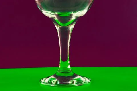 Conceptually lighted wine glass on a multicolored background Stock Photos