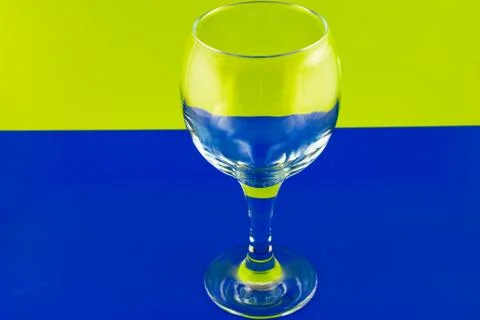 Conceptually lighted wine glass on a multicolored background Stock Photos