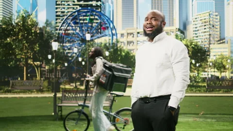 Concerned businessman checking time on smartwatch while standing in city park Stock Footage 343506181