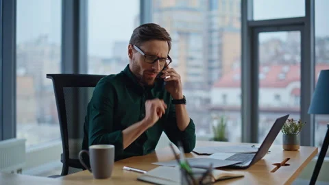 Concerned executive speaking mobile phone at workspace with laptop closeup. Stock Footage 340236958