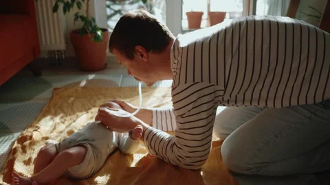 Concerned father using a nasal aspirator to clear newborn baby's stuffy nose Stock Footage 346028102
