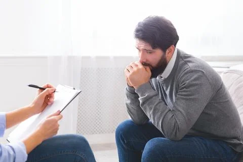 Concerned Man Discussing Problems With Counselor During Therapy Session 스톡 사진