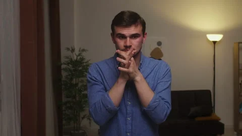 Concerned Man at Home Clasping Hands Together in Worry During Evening Video stock 269801185