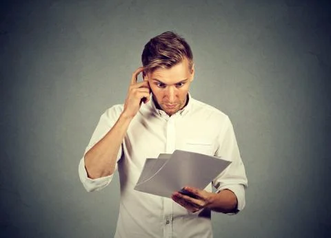Concerned man reading paper documents Stock Photos
