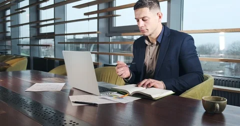 Concerned man working on laptop computer and looking away thinking solving Stock Footage 122122366
