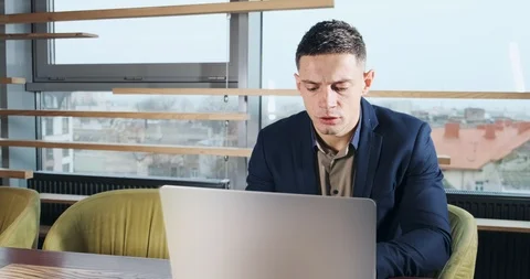 Concerned man working on laptop computer and looking away thinking solving Stock Footage 122199160