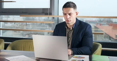 Concerned man working on laptop computer and looking away thinking solving Stock Footage 122743546
