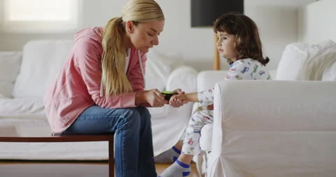 Concerned mother checking her sons oxygen levels with a pulse oximeter at home Stock Footage 275205187