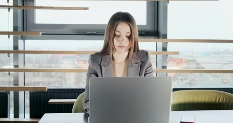 Concerned woman working on laptop computer and looking away thinking solving Stock Footage 120481905
