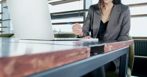 Concerned woman working on laptop computer and looking away thinking solving Видео 120483243