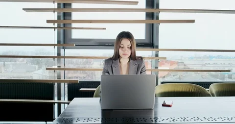 Concerned woman working on laptop computer and looking away thinking solving Stock Footage 121525852