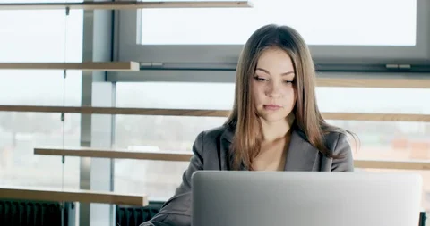 Concerned woman working on laptop computer and looking away thinking solving Stock Footage 121526613