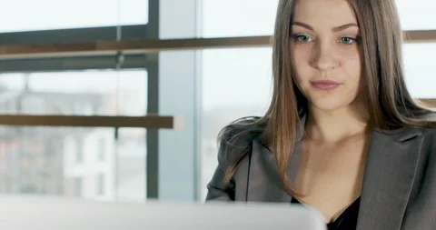Concerned woman working on laptop computer and looking away thinking solving Stock Footage 121527063