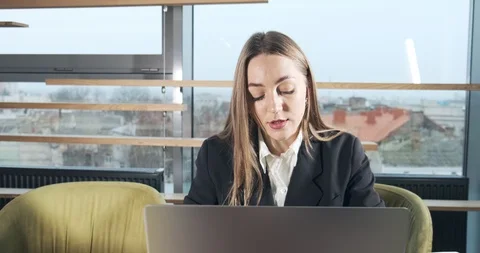 Concerned woman working on laptop computer and looking away thinking solving Stock Footage 121842825