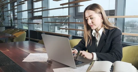 Concerned woman working on laptop computer and looking away thinking solving Stock Footage 122122845