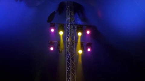 Concert equipment with multi colored spotlights in the dark of the circus arena. Stock Footage 308471044