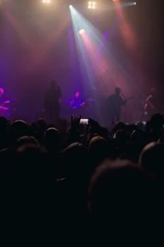 Concert goer taking photos with mobile of rock band. Foto stock