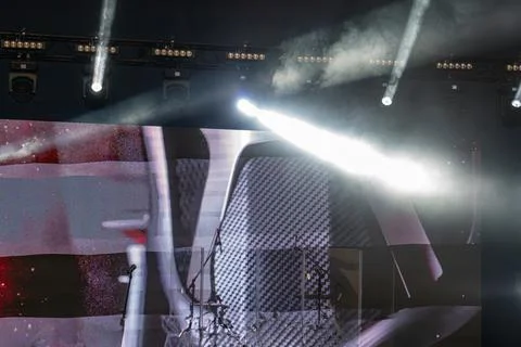 Concert stage setup with large projection screen displaying band members, dyn Stock Photos