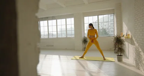 Concetrated female yoga practitioner doing a warrior position. Fit athletic girl Video stock 150715307