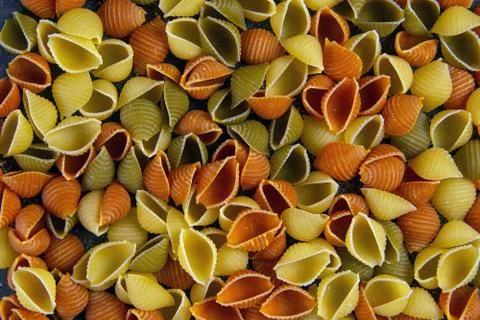 Conchiglie paste of different colors isolated on black background Stock Photos