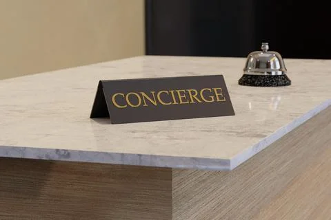 Concierge sign on a white marble table at a hotel reception desk with a silv Stock Illustration