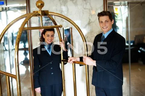 Concierges holding the cart and posing Stock Photos