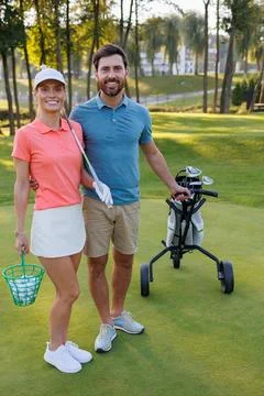 Concluding Flag: Young Pair and Golfing Equipment Fotos Stock