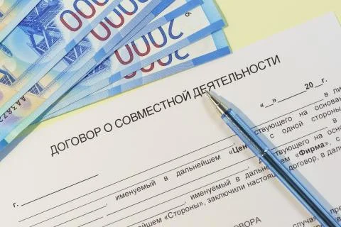 Conclusion of a joint activity agreement. Form, money, and pen on the yellow  Stock-Fotos