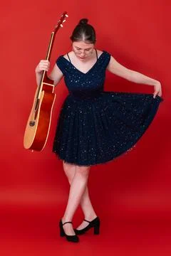 At conclusion of performance, female guitarist performs curtsy and bows her h Stock Photos