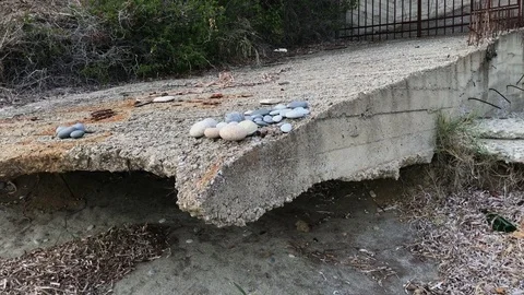 Concrete area that washed away by waves of the sea on the beach Stock Footage 80592865