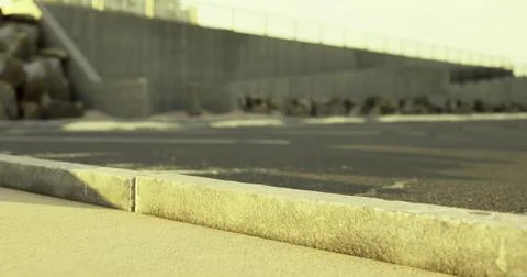 Concrete barrier alongside empty road during golden hour light Stock Illustration
